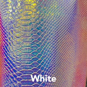 Könnte beinhalten: Nahaufnahme von irisierendem, weißem Kunst-Schlangenlederstoff mit einem strukturierten Muster. Der Stoff hat einen subtilen Schimmer und eine leicht erhabene Textur.