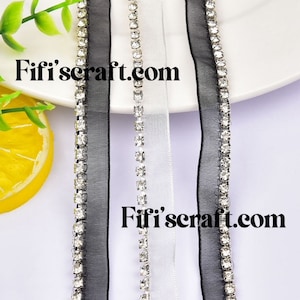 May include: Three strands of ribbon trim with a row of clear rhinestones along the edge. The ribbon is black, white, and black. The text "Fifi's craft.com" is visible in the image.
