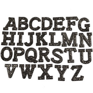 May include: A set of 26 black iron-on letters, each letter is covered in rhinestones. The letters are in uppercase and are arranged in alphabetical order.