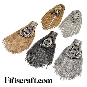 May include: Four decorative metal chain fringe patches with ornate embellishments. The patches are in gold, silver, black, and a mix of silver and black.