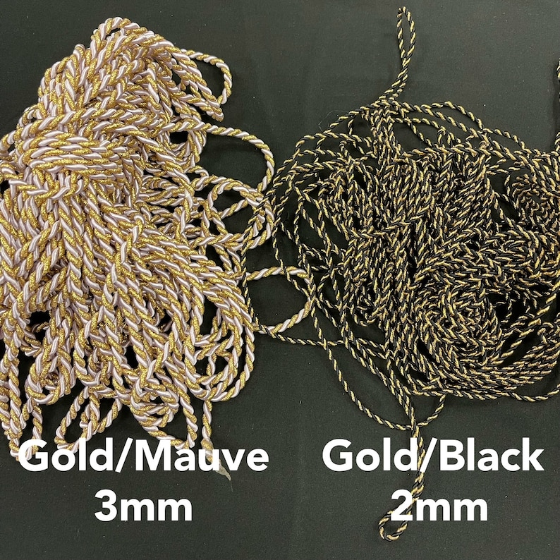 May include: Two bundles of twisted cord. The left bundle is gold and mauve with a 3mm thickness. The right bundle is gold and black with a 2mm thickness. Text below the cords reads Gold/Mauve 3mm and Gold/Black 2mm respectively.