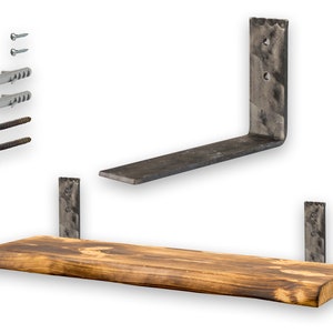 Peut inclure: Une étagère en bois rustique avec un bord incurvé, soutenue par deux supports en métal noir. L'étagère est livrée avec du matériel de montage, y compris des vis et des chevilles.