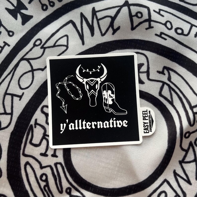 May include: Black and white sticker with a bull skull, a cowboy boot, and a barbed wire lasso. The text "y'allternative" is below the image.