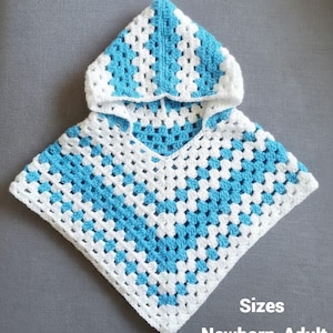 Puede incluir: Un poncho de ganchillo hecho a mano con un patrón de granny square. El poncho es blanco con secciones en azul claro. El texto "Sizes Newborn-Adult" es visible.