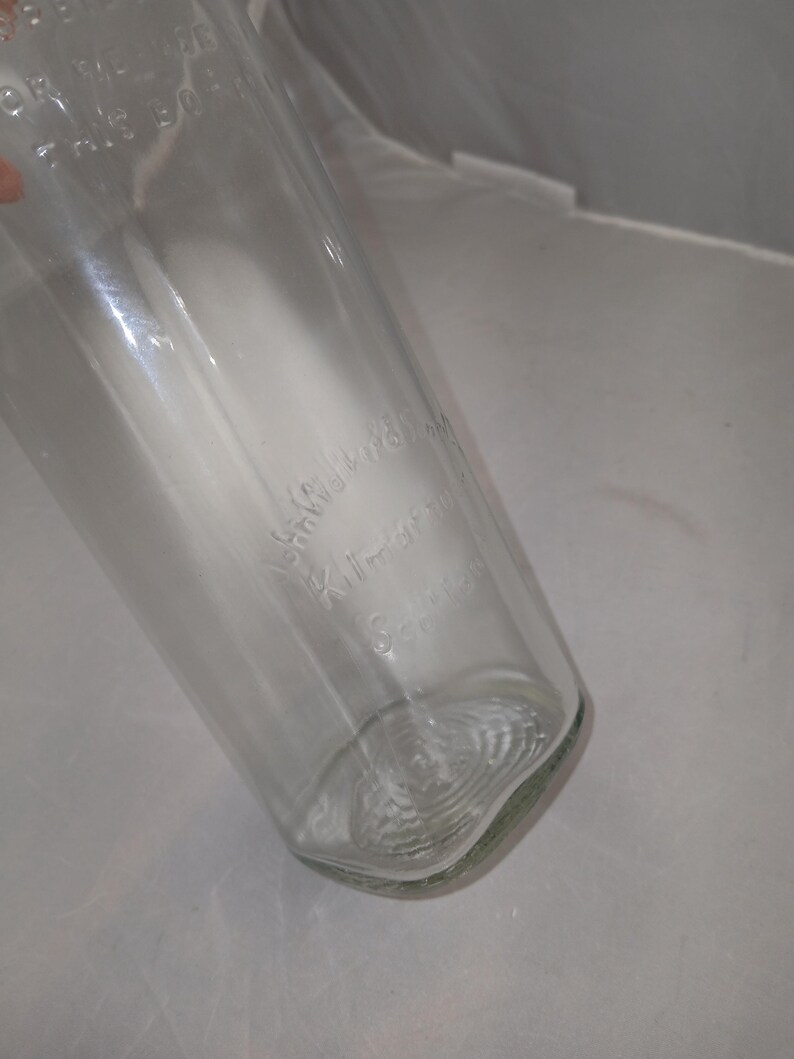 May include: A clear glass bottle with the embossed text "Kitchen Science". The bottle has a rounded base and a slightly tapered shape. The glass appears to be clean and free of any major imperfections.