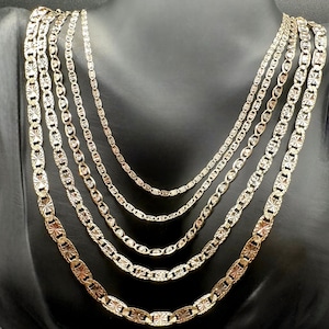 May include: Five gold chains of different lengths and widths, all with a textured, diamond-cut design. The chains are displayed on a black velvet mannequin.