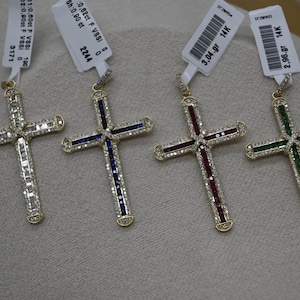 Puede incluir: Cuatro colgantes de cruz de oro con piedras preciosas de diferentes colores. Las cruces est&aacute;n engastadas con peque&ntilde;os diamantes y tienen una etiqueta de oro de 14 quilates.