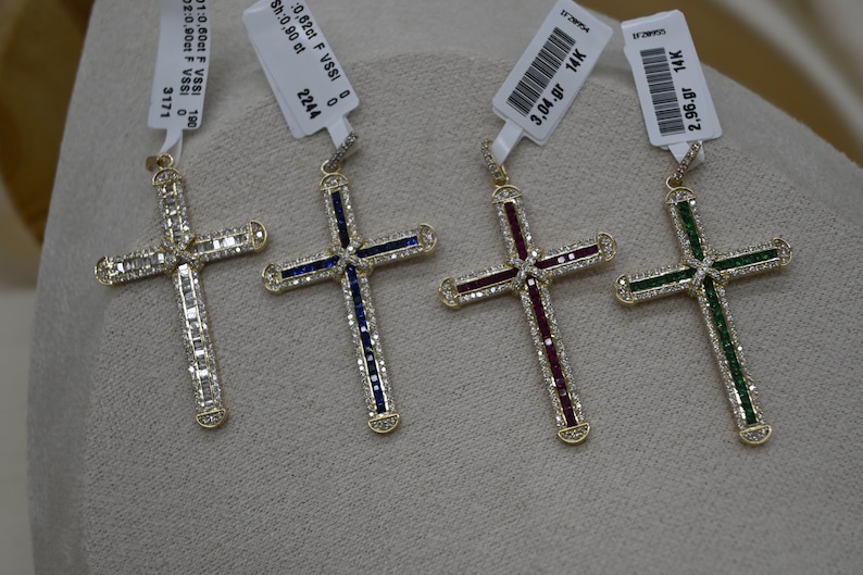 Puede incluir: Cuatro colgantes de cruz de oro con piedras preciosas de diferentes colores. Las cruces est&aacute;n engastadas con peque&ntilde;os diamantes y tienen una etiqueta de oro de 14 quilates.