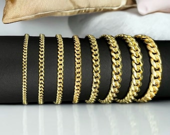 May include: A set of seven gold curb chain bracelets of varying widths, displayed on a black surface.  The bracelets are arranged in order of size, with the smallest on the left and the largest on the right.  The image is labeled "F.Z Gold NYC".