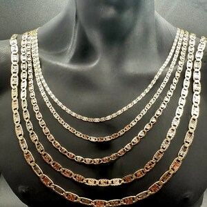 May include: A set of six gold chains with different lengths and widths. The chains are made of a shiny metal and have a textured design.