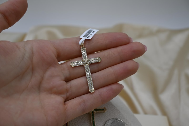 Puede incluir: Un colgante de cruz de oro con diamantes de talla baguette. La cruz est&aacute; engastada con diamantes en ambos lados y tiene un acabado pulido.