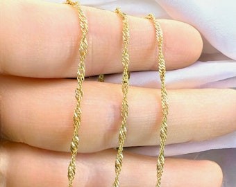 May include: Three gold chains of different lengths, all with a twisted rope design. The chains are laid out on a hand, with the shortest chain on top and the longest chain on the bottom.