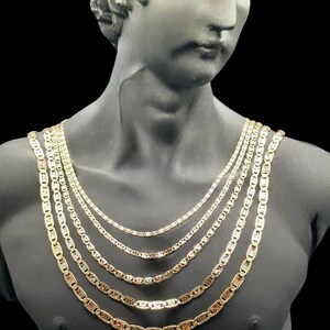 May include: A set of five gold mariner chains of varying lengths, displayed on a mannequin bust.