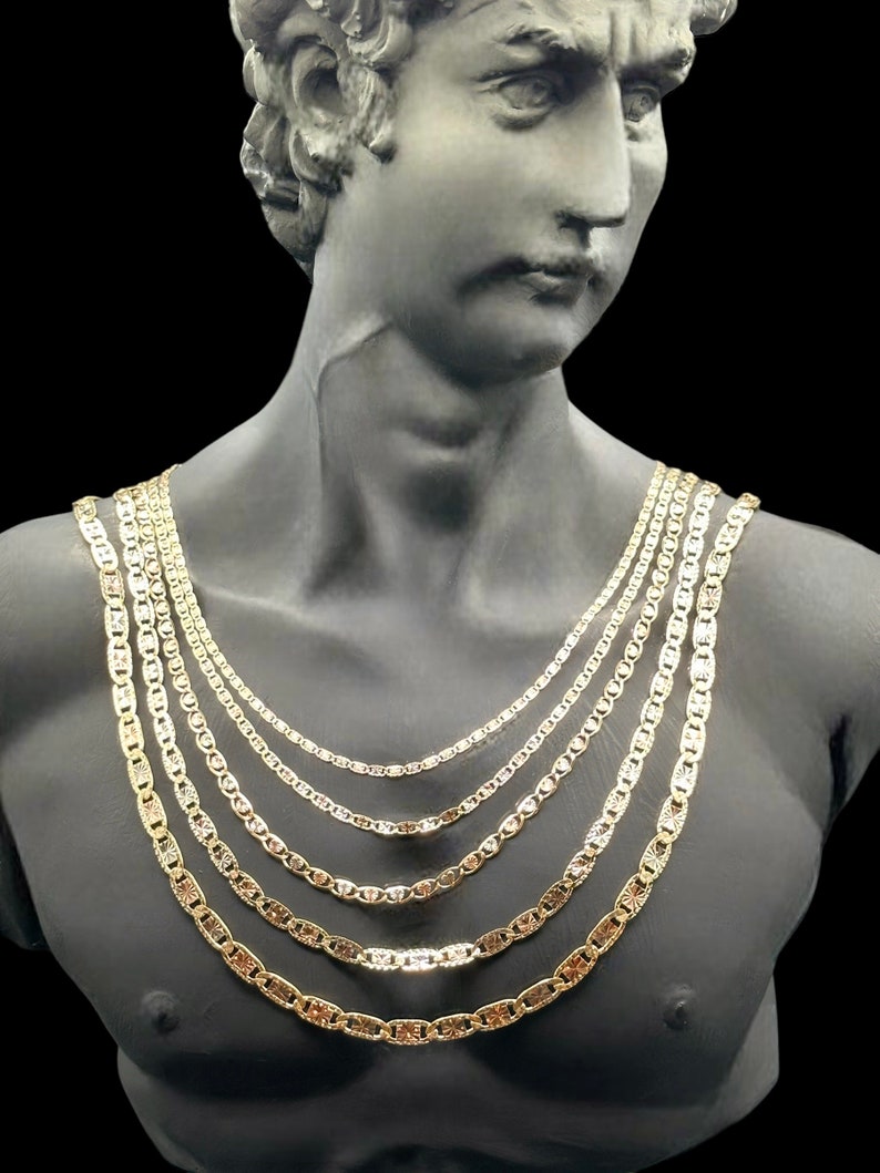 May include: A set of five gold mariner chains of varying lengths, displayed on a mannequin bust.