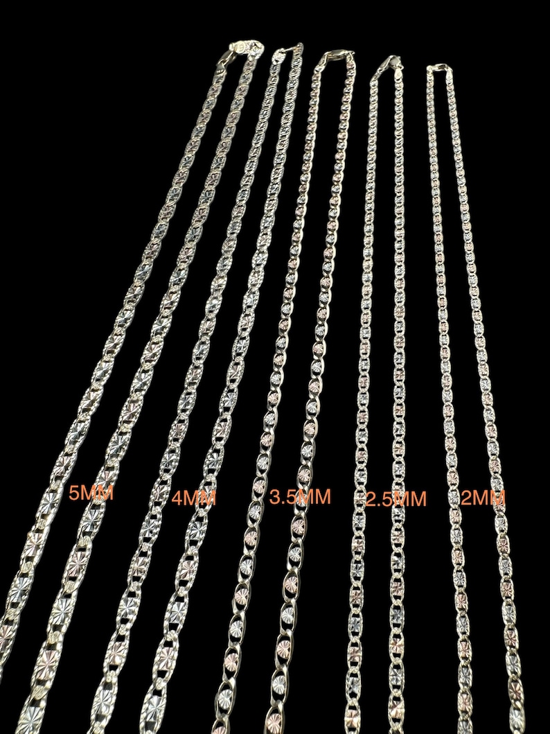 May include: Five silver chains of different widths, ranging from 2mm to 5mm. The chains are all made of a silver metal with a polished finish. The chains are arranged in order of size, with the smallest chain on the right and the largest chain on the left.