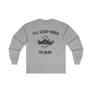 May include: A gray long-sleeve t-shirt with the text "I'll sleep when I'm dead" and a black bird with arrows through it.