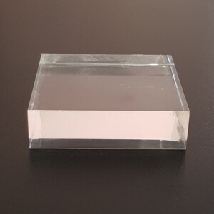 Puede incluir: Un expositor de acr&iacute;lico transparente con forma rectangular. El expositor est&aacute; hecho de acr&iacute;lico transparente grueso y tiene una superficie lisa y pulida.