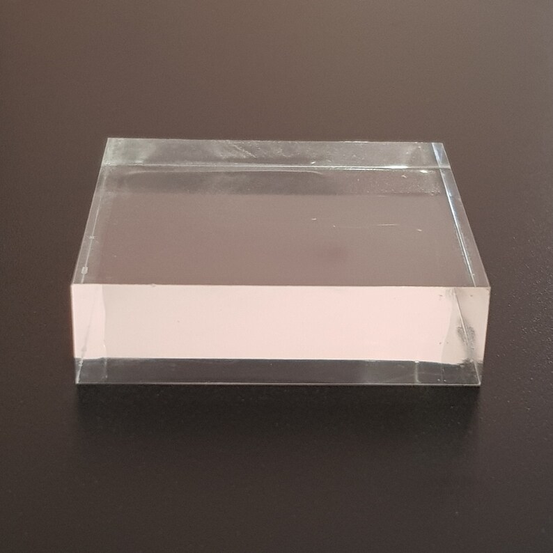 Puede incluir: Un expositor de acr&iacute;lico transparente con forma rectangular. El expositor est&aacute; hecho de acr&iacute;lico transparente grueso y tiene una superficie lisa y pulida.