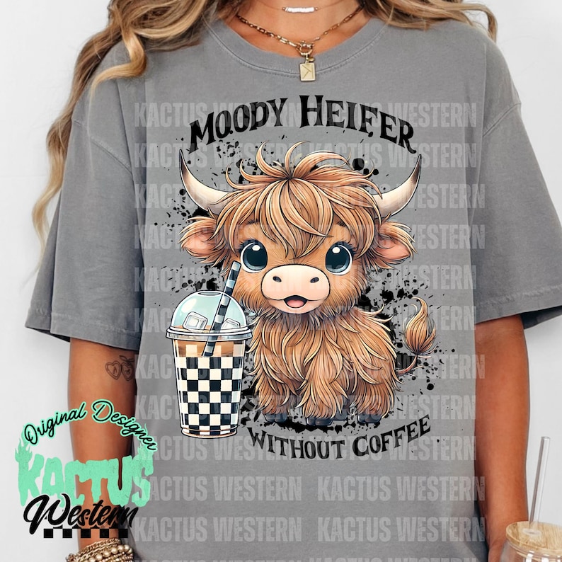 May include: Gray t-shirt with a cartoon illustration of a brown and white Highland cow with the text "Moody Heifer Without Coffee" printed on the front.