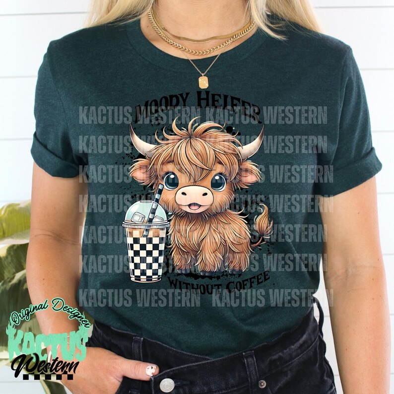 May include: A green t-shirt with a cartoon highland cow holding a checkered cup of iced coffee. The text "MOODY HEIFER WITHOUT COFFEE" is printed on the shirt.