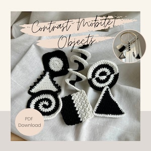May include: Black and white crocheted shapes for a baby mobile. The shapes include a spiral, circles, squares, and triangles. The text "Contrast Mobile Objects" and "PDF Download" are visible in the image.