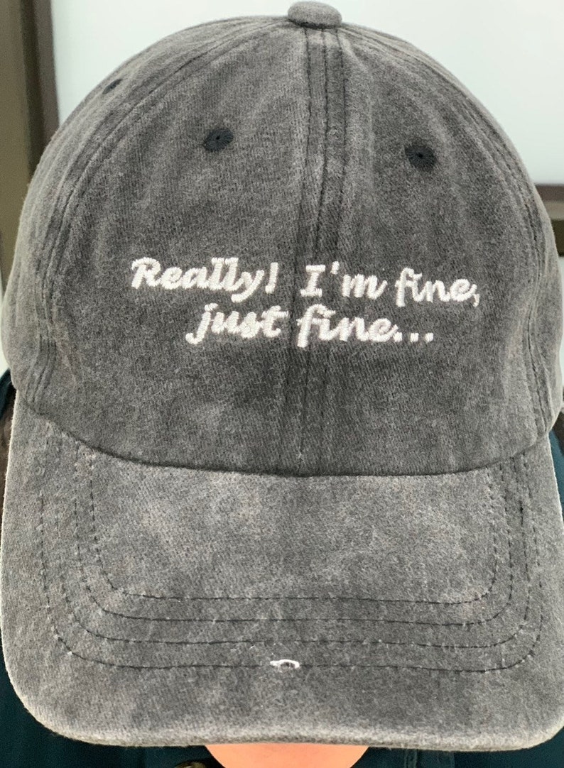 K&ouml;nnte beinhalten: Eine schwarze Baseballkappe mit dem Text "Really! I'm fine, just fine..." in wei&szlig; gestickt.