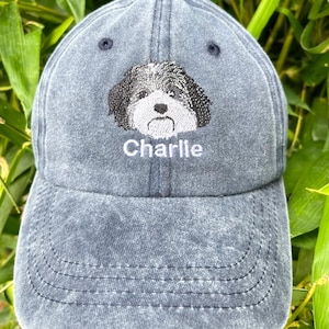 Könnte beinhalten: Eine dunkelblaue Baseballkappe aus Denim mit einem gestickten Bild eines schwarz-weißen Hundes und dem Namen "Charlie", der in weißer Farbe gestickt ist.