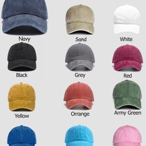 May include: A color chart displaying twelve baseball caps in various colors including navy, sand, white, black, grey, red, yellow, orange, army green, blue, light blue, and pink. Each cap features a six-panel design with a curved brim.