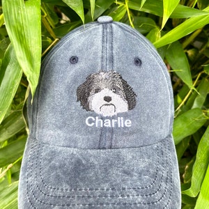 Pode incluir: Um bon&eacute; de beisebol de denim azul escuro com uma imagem bordada de um c&atilde;o e o nome "Charlie" bordado em fio branco.