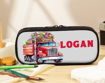 May include: A black pencil case with a zipper closure. The case features a colorful illustration of a red truck carrying books and the name "LOGAN" in red letters.