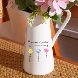 May include: White ceramic pitcher with a handle, featuring the text "Grandma's Garden Love Grows Here" with three flowers and names "Andrew", "Kirsten", and "Barry" underneath.