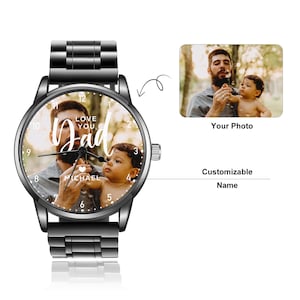 May include: A black wristwatch with a photo of a man and a child on the watch face. The words "LOVE YOU Dad" are in white script. The name "MICHAEL" is below the photo. The watch has a black metal band.