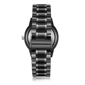 K&ouml;nnte beinhalten: Eine schwarze Armbanduhr mit einem Metallband. Die Uhr hat ein rundes Zifferblatt und ein silbernes Zifferblatt.