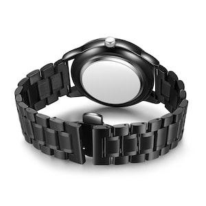 May include: A black wristwatch with a matching black metal band. The watch face is round, and the band is composed of rectangular links. The clasp is visible, and the back of the watch is a light silver color.