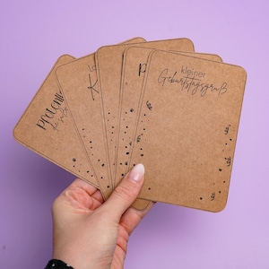 Puede incluir: Un conjunto de seis tarjetas marrones con texto negro. Las tarjetas tienen un patrón de puntos y el texto "kleiner Geburtstagsgruß" en una tarjeta.