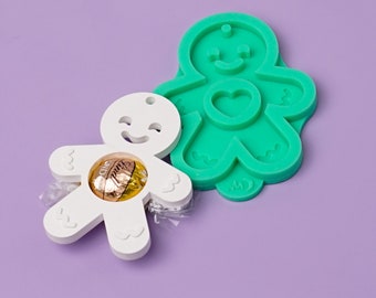 Puede incluir: Molde de hombre de jengibre blanco con un corazón en el pecho y un caramelo de chocolate en su interior. Molde de hombre de jengibre verde con un corazón en el pecho.