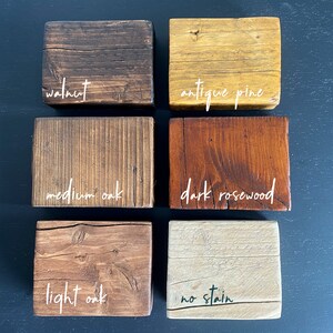 K&ouml;nnte beinhalten: Sechs Holzproben, die in verschiedenen Farben gebeizt sind, darunter Walnuss, antiker Kiefer, mittlere Eiche, dunkles Palisander, helle Eiche und unbefleckt.