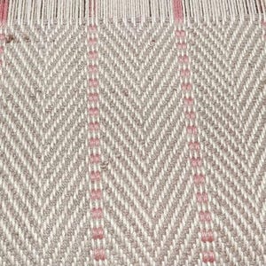 May include: Close-up of a woven textile with a herringbone pattern. The fabric features a neutral beige and white color scheme with vertical accents of pink. The weaving is detailed and shows the texture of the threads.