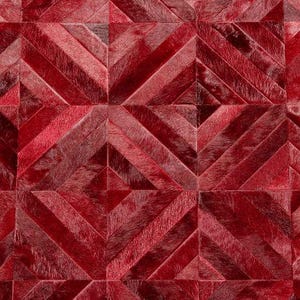 Puede incluir: Primer plano de un patrón geométrico rojo. El diseño presenta un patrón repetitivo de líneas y formas angulares en diferentes tonos de rojo, creando una superficie texturizada y llamativa. El efecto general es un diseño moderno y abstracto.