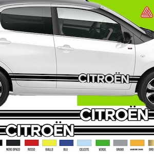 Op de afbeelding: Witte Citroën auto met zwarte accenten, waaronder strepen en de merknaam. De afbeelding toont ook een voorbeeld van het Citroën logo en kleuropties. De auto heeft zwarte wielen.