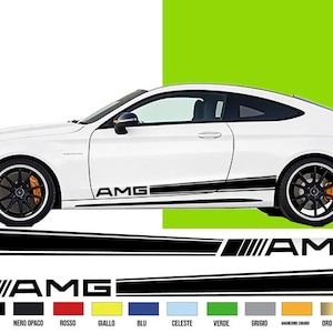 Könnte beinhalten: Ein weißes Coupé mit schwarzen AMG-Seitenstreifen und schwarzen Rädern. Das Bild enthält eine Grafik des AMG-Logos und Farbmuster. Das Auto hat orangefarbene Bremssättel.
