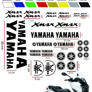 Può includere: Una collezione di adesivi Yamaha e Xmax in varie dimensioni e colori, tra cui bianco, blu, verde, rosso, oro, giallo, argento e nero. Il logo Yamaha e il testo Xmax sono in evidenza, con misure in centimetri.