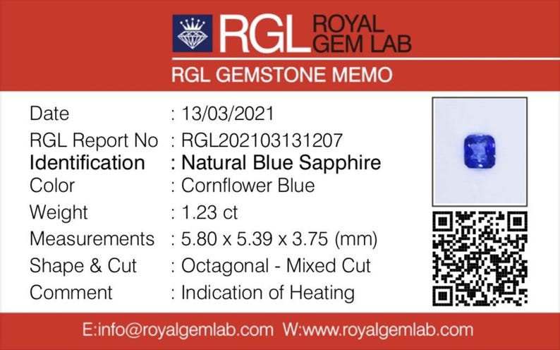 May include: A gemstone memo from Royal Gem Lab. The memo details a natural blue sapphire with a cornflower blue color. The gemstone weighs 1.23 ct and measures 5.80 x 5.39 x 3.75 mm. The shape is octagonal with a mixed cut.