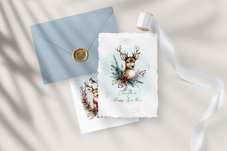 May include: Two watercolor Christmas cards featuring a deer with a wreath of holly and berries. The card on the left has a small bird perched on the wreath. The card on the right has a larger deer with the text "Merry Christmas Happy New Year".