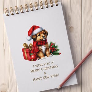 May include: A spiral-bound notepad with a Christmas illustration. A puppy wearing a Santa hat and scarf sits next to a wrapped gift and ornaments. The text reads, "I wish you a Merry Christmas & Happy New Year!" A pencil rests on the wooden surface.