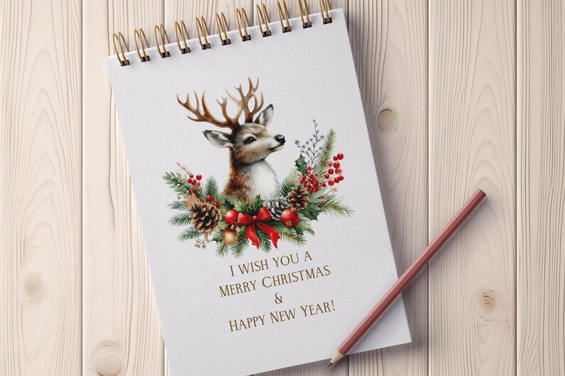May include: A white spiral notebook with a watercolor illustration of a deer with antlers surrounded by a wreath of pine branches, red berries, and a red bow. The text "I wish you a Merry Christmas & Happy New Year!" is printed below the illustration.