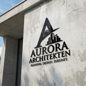 Könnte beinhalten: Schwarzes Logo von Aurora Architekten an einer Betonwand. Das Logo zeigt ein stilisiertes "A" mit Sonne und Stadtlandschaft. Darunter stehen die Worte "AURORA ARCHITEKTEN" und "PLANUNG. DESIGN. ZUKUNFT."