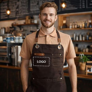 Puede incluir: Un delantal marrón con correas de cuero y anillos metálicos. El delantal tiene un bolsillo y una caja blanca con la palabra "LOGO" en su interior. La persona lleva un polo beige.