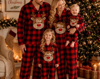 May include: Matching red and black buffalo plaid pajama sets featuring a central reindeer graphic with a red nose. Each shirt displays a name tag: Dad, Mom, Emily, and Noah. The long-sleeved button-down tops and matching pants are made of fabric.