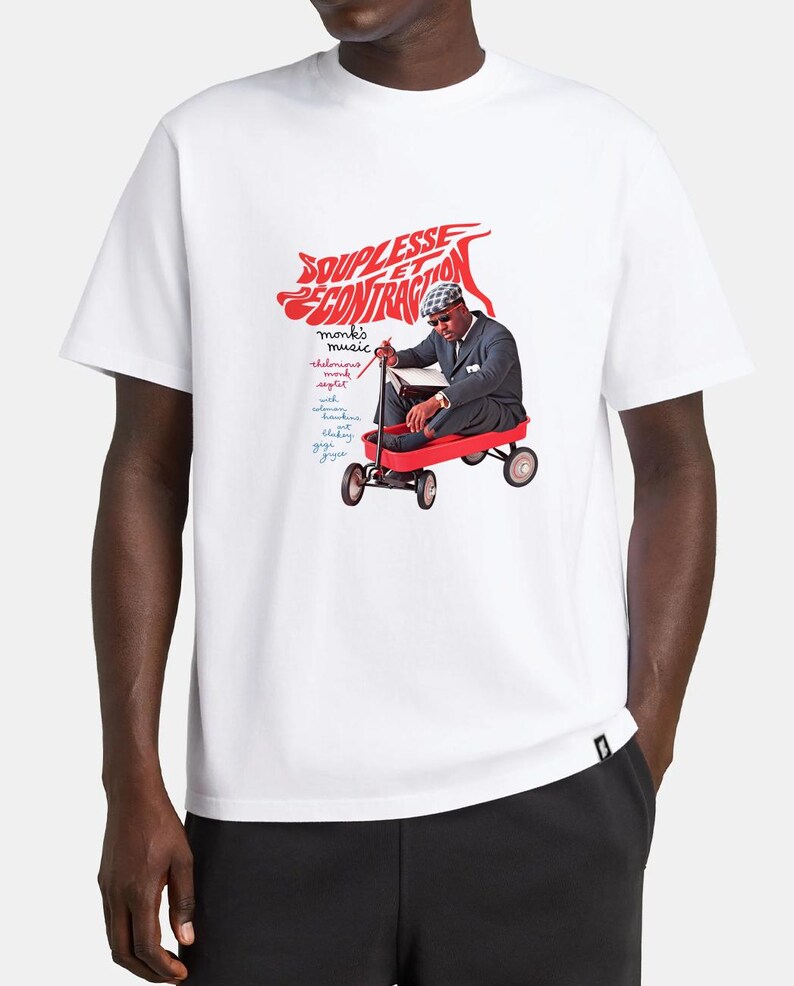 May include: A white short-sleeve t-shirt featuring a graphic print of a person in a suit and hat sitting in a red wagon. The text reads SOUPLESSE ET CONTRACTION, monk's music, thelonious monk, septet, with coleman hawkins, blakey, gigi gryce.